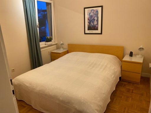 Helles Schlafzimmer mit Doppelbett, Nachttischen und einem Gemälde an der Wand.